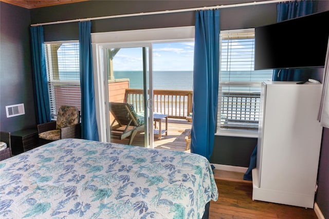 bedroom featuring access to outside, visible vents, baseboards, and wood finished floors