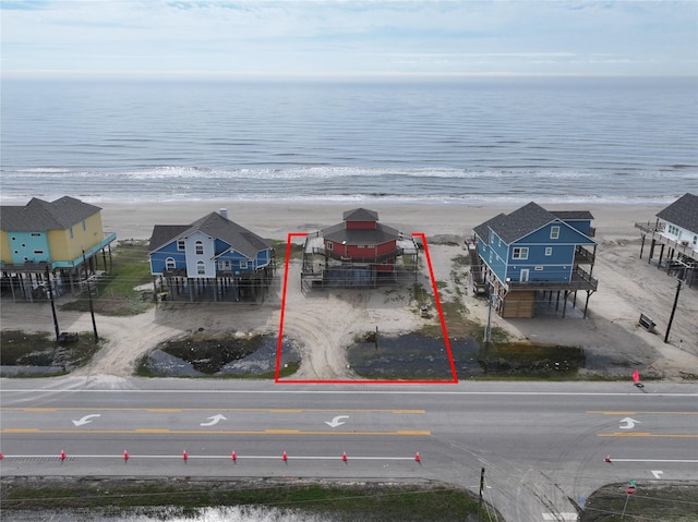 birds eye view of property with a water view and a beach view