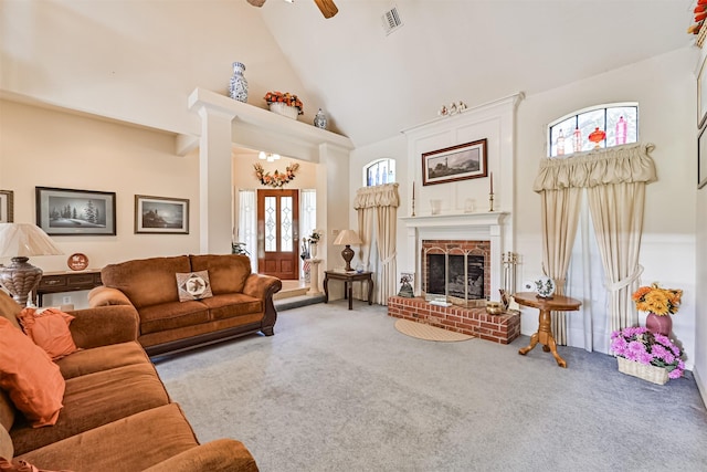 living area featuring visible vents, a ceiling fan, carpet, a brick fireplace, and high vaulted ceiling