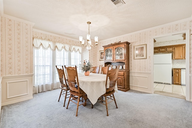 dining space featuring wainscoting, light colored carpet, visible vents, and wallpapered walls