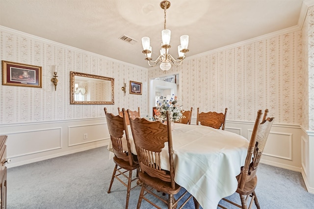 dining area with carpet floors, a wainscoted wall, visible vents, a chandelier, and wallpapered walls