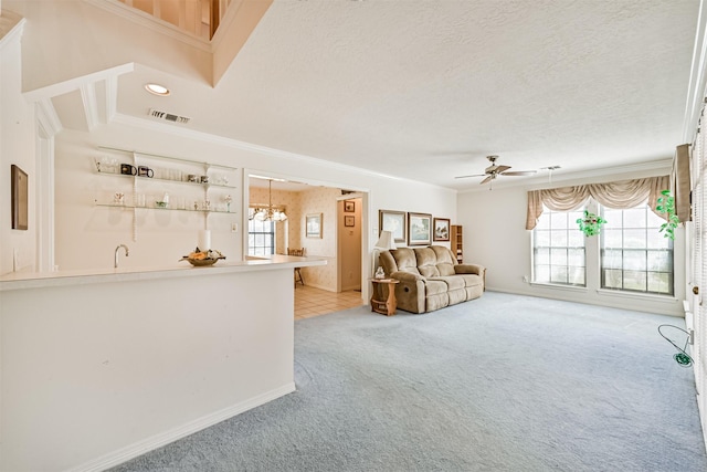 unfurnished living room featuring visible vents, ornamental molding, light carpet, a textured ceiling, and ceiling fan with notable chandelier