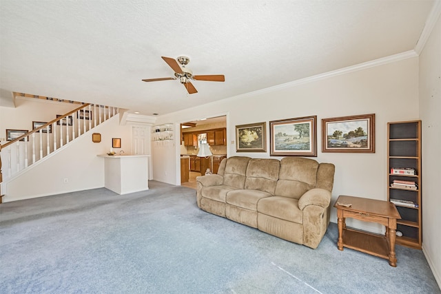 living room with ceiling fan, light colored carpet, crown molding, and stairs