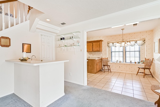 kitchen featuring brown cabinets, light tile patterned flooring, visible vents, and wallpapered walls