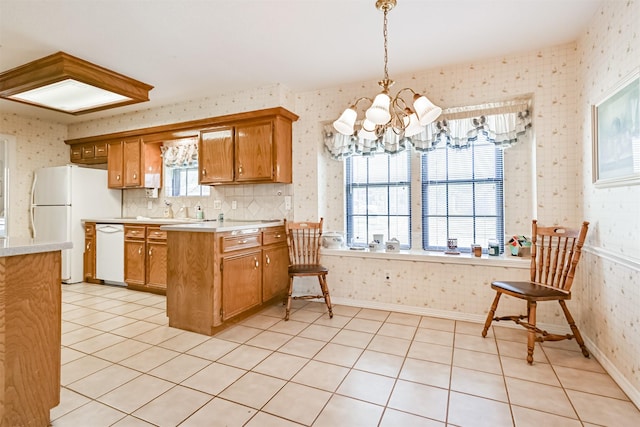 kitchen with light countertops, white appliances, brown cabinetry, and wallpapered walls