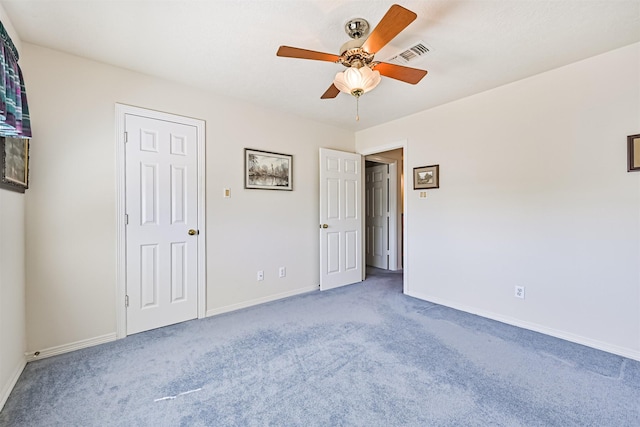 unfurnished bedroom with carpet, visible vents, and baseboards