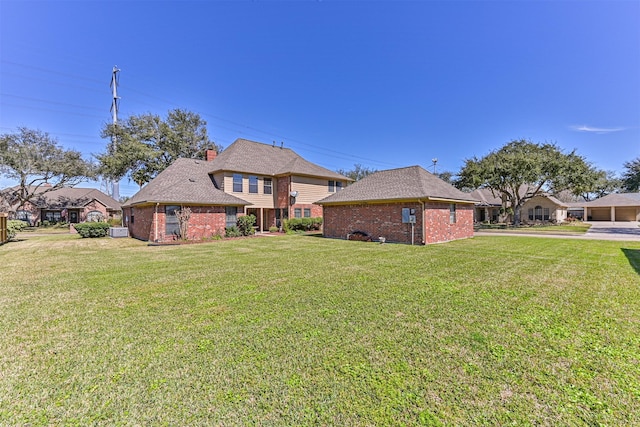 view of front facade with brick siding and a front lawn