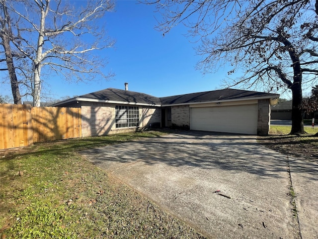 view of front of house with a garage, brick siding, driveway, and fence