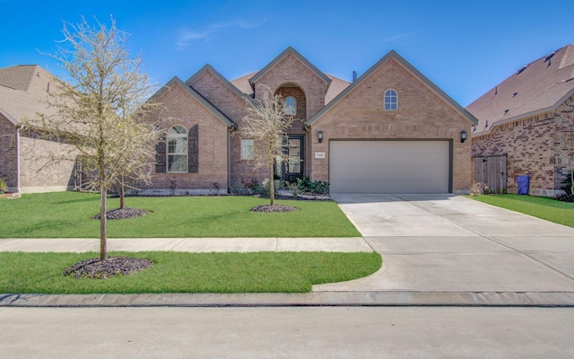 view of front of house with driveway, an attached garage, a front lawn, and brick siding