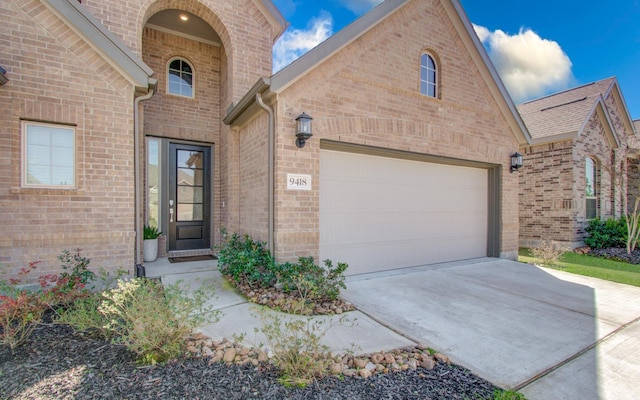 view of front of home featuring a garage, driveway, and brick siding