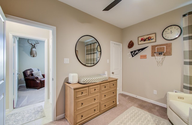 sitting room featuring ceiling fan, baseboards, and light colored carpet