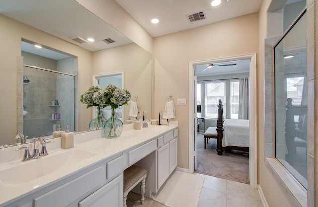 ensuite bathroom featuring visible vents, a sink, a tile shower, and tile patterned floors