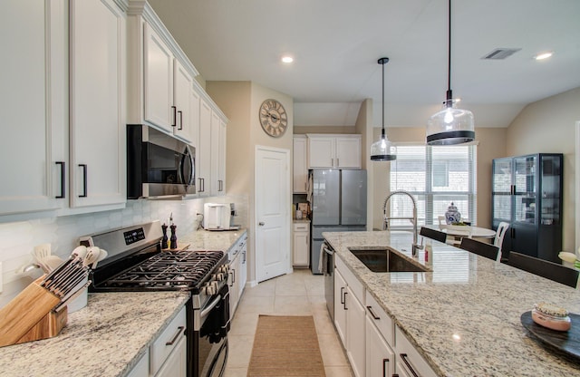 kitchen with light tile patterned flooring, a sink, visible vents, appliances with stainless steel finishes, and backsplash