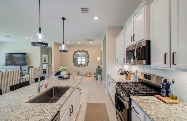 kitchen with a sink, visible vents, stainless steel appliances, and decorative backsplash