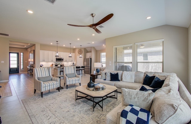 living area with lofted ceiling, light tile patterned flooring, visible vents, and recessed lighting