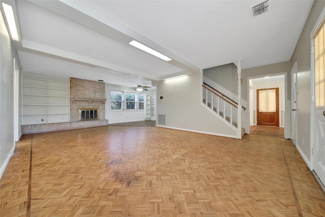 unfurnished living room with baseboards, stairs, visible vents, and a textured ceiling