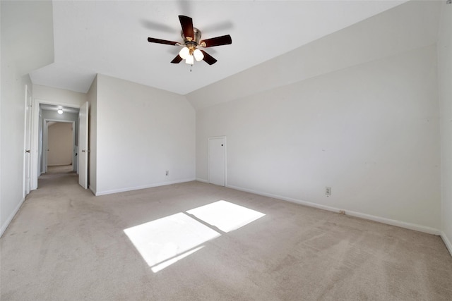 interior space featuring light carpet, ceiling fan, baseboards, and vaulted ceiling