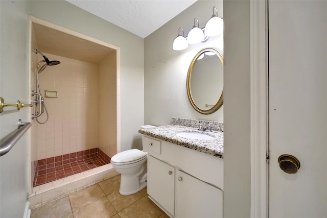 full bathroom with a stall shower, toilet, tile patterned flooring, a textured ceiling, and vanity