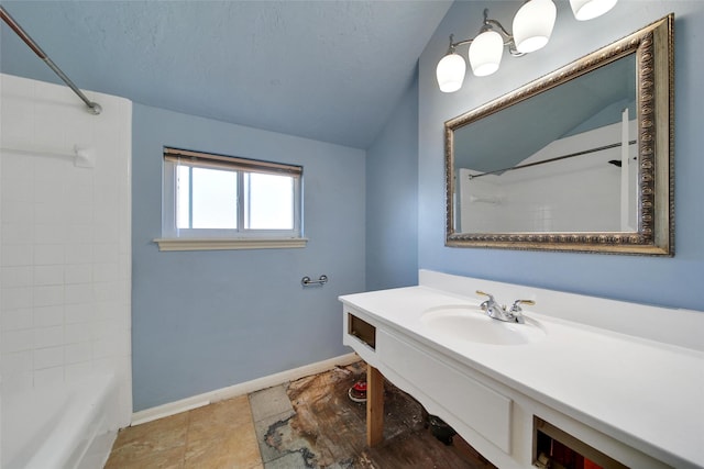 full bathroom with baseboards,  shower combination, vaulted ceiling, a textured ceiling, and vanity