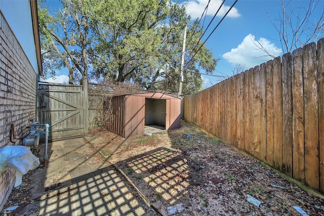 view of yard featuring a storage unit, an outdoor structure, and a fenced backyard