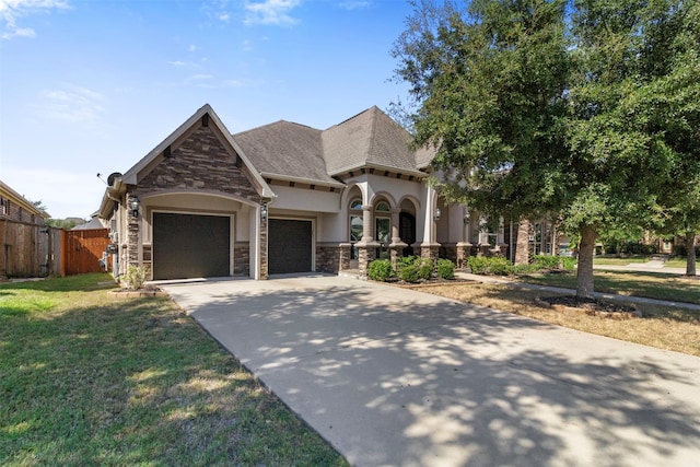 view of front of home with an attached garage, fence, stone siding, concrete driveway, and a front yard