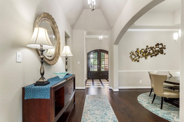 foyer with arched walkways, french doors, wood-type flooring, and baseboards