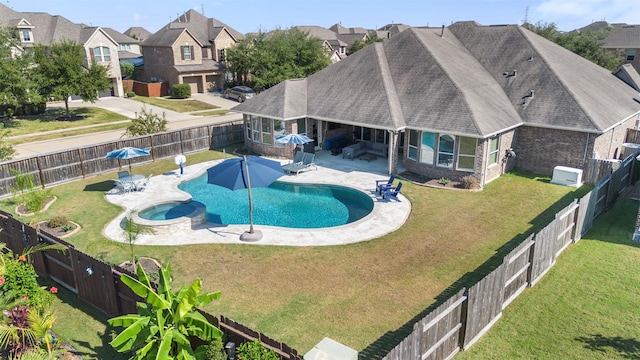 view of pool featuring a yard, a patio area, a fenced backyard, and a pool with connected hot tub