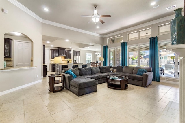 living area with light tile patterned floors, baseboards, visible vents, ornamental molding, and ceiling fan with notable chandelier