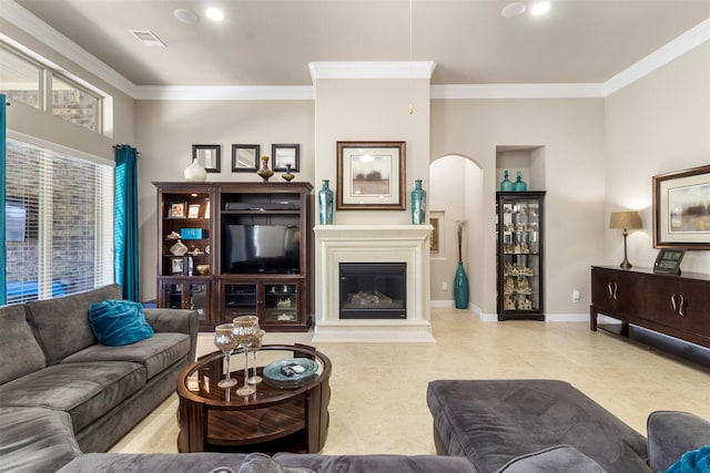 living area featuring ornamental molding, a glass covered fireplace, arched walkways, and baseboards