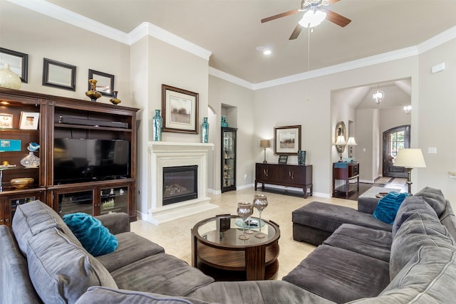 living room with baseboards, ornamental molding, ceiling fan, and a glass covered fireplace