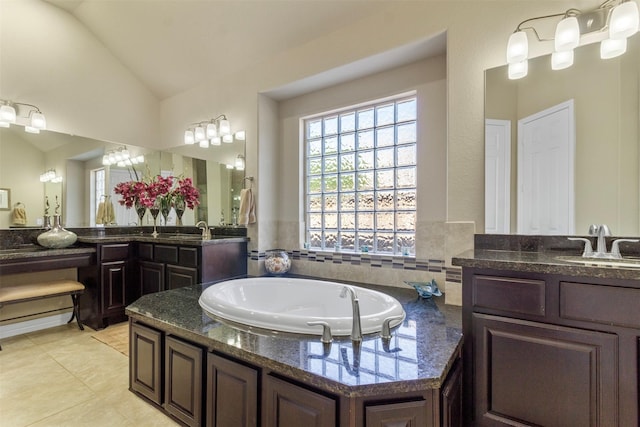 bathroom featuring lofted ceiling, tile patterned flooring, vanity, and a bath