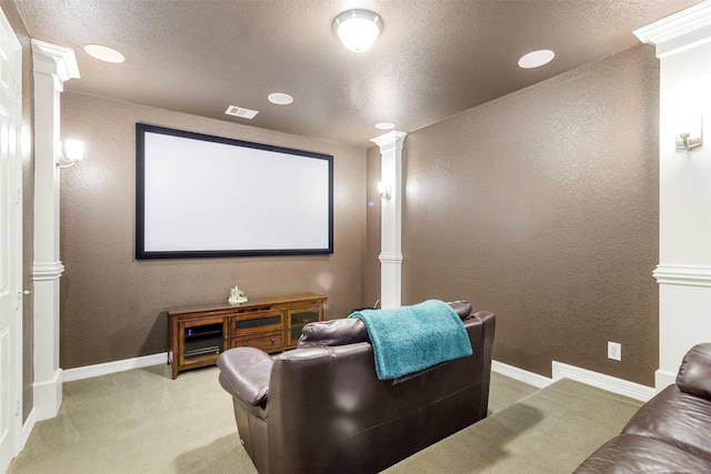 home theater with light carpet, ornate columns, baseboards, and a textured ceiling