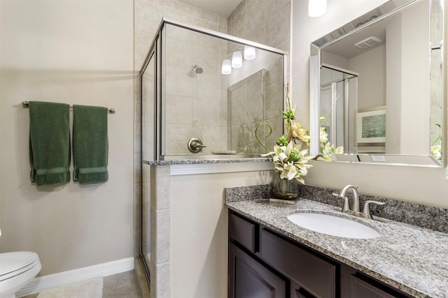 bathroom featuring visible vents, baseboards, toilet, vanity, and a shower stall