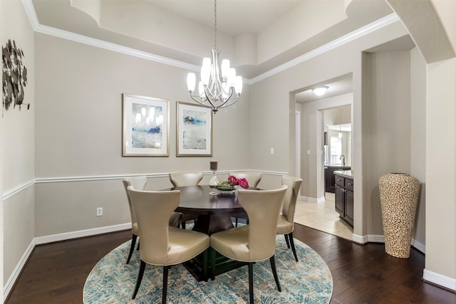 dining room featuring a tray ceiling, baseboards, and hardwood / wood-style floors