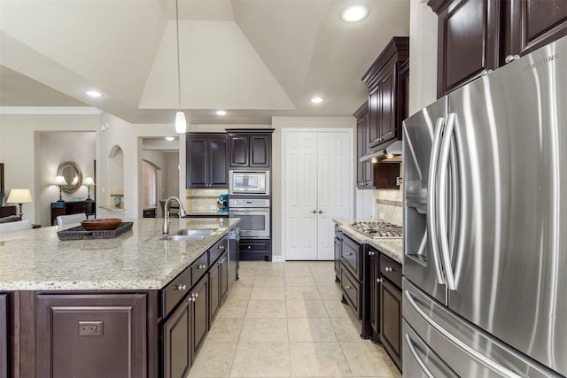 kitchen featuring stainless steel appliances, lofted ceiling, a sink, dark brown cabinetry, and under cabinet range hood