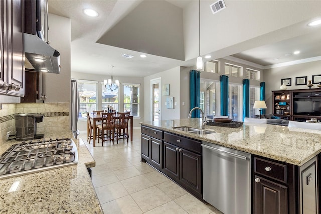 kitchen with stainless steel appliances, tasteful backsplash, visible vents, open floor plan, and a sink