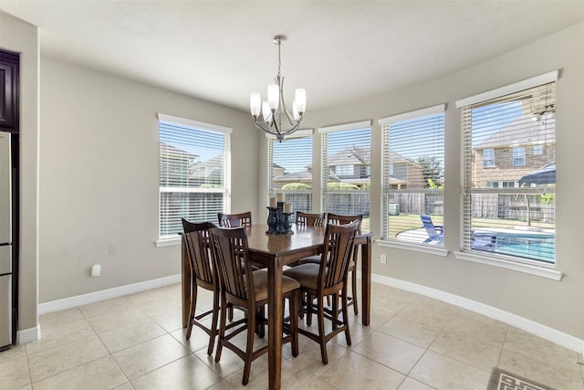 dining room featuring light tile patterned floors, baseboards, and a chandelier