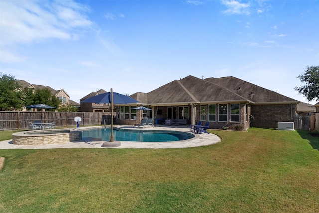 view of pool featuring a yard, a patio area, a fenced backyard, and a pool with connected hot tub