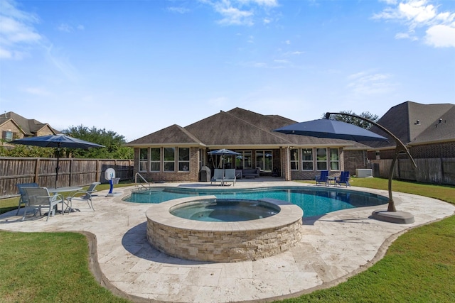 view of swimming pool featuring a lawn, a patio area, a fenced backyard, and a pool with connected hot tub