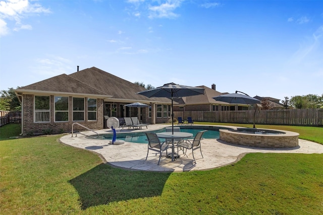 view of pool with a patio area, a fenced backyard, a pool with connected hot tub, and a lawn