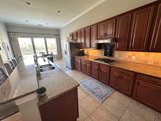 kitchen featuring ornamental molding, a sink, stainless steel appliances, under cabinet range hood, and backsplash