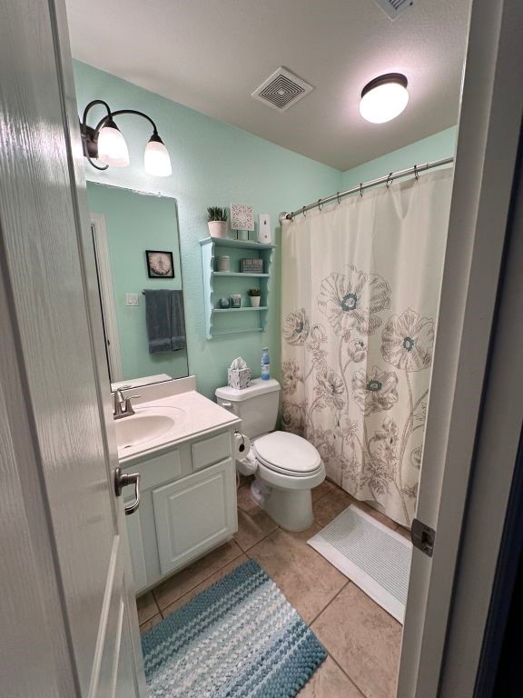 bathroom featuring visible vents, toilet, a shower with curtain, tile patterned floors, and vanity