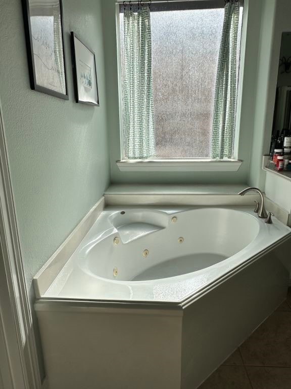 full bathroom featuring tile patterned flooring and a tub with jets