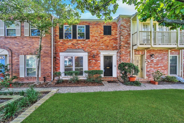 view of property featuring a front lawn and brick siding