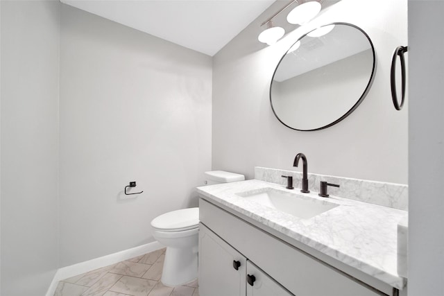 half bath featuring marble finish floor, vanity, toilet, and baseboards