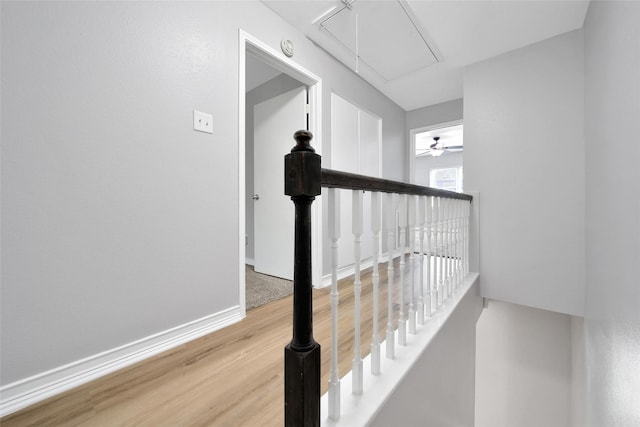 staircase with attic access, baseboards, and wood finished floors