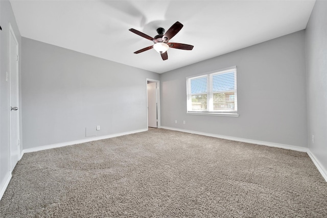 carpeted empty room with ceiling fan and baseboards