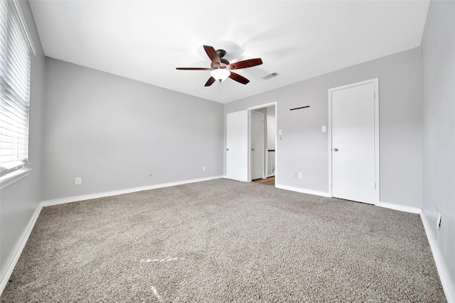 unfurnished bedroom featuring baseboards, visible vents, ceiling fan, and carpet flooring