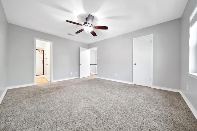 unfurnished bedroom featuring carpet floors, visible vents, baseboards, and a ceiling fan