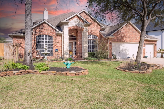 view of front facade with a chimney, concrete driveway, a garage, a lawn, and brick siding